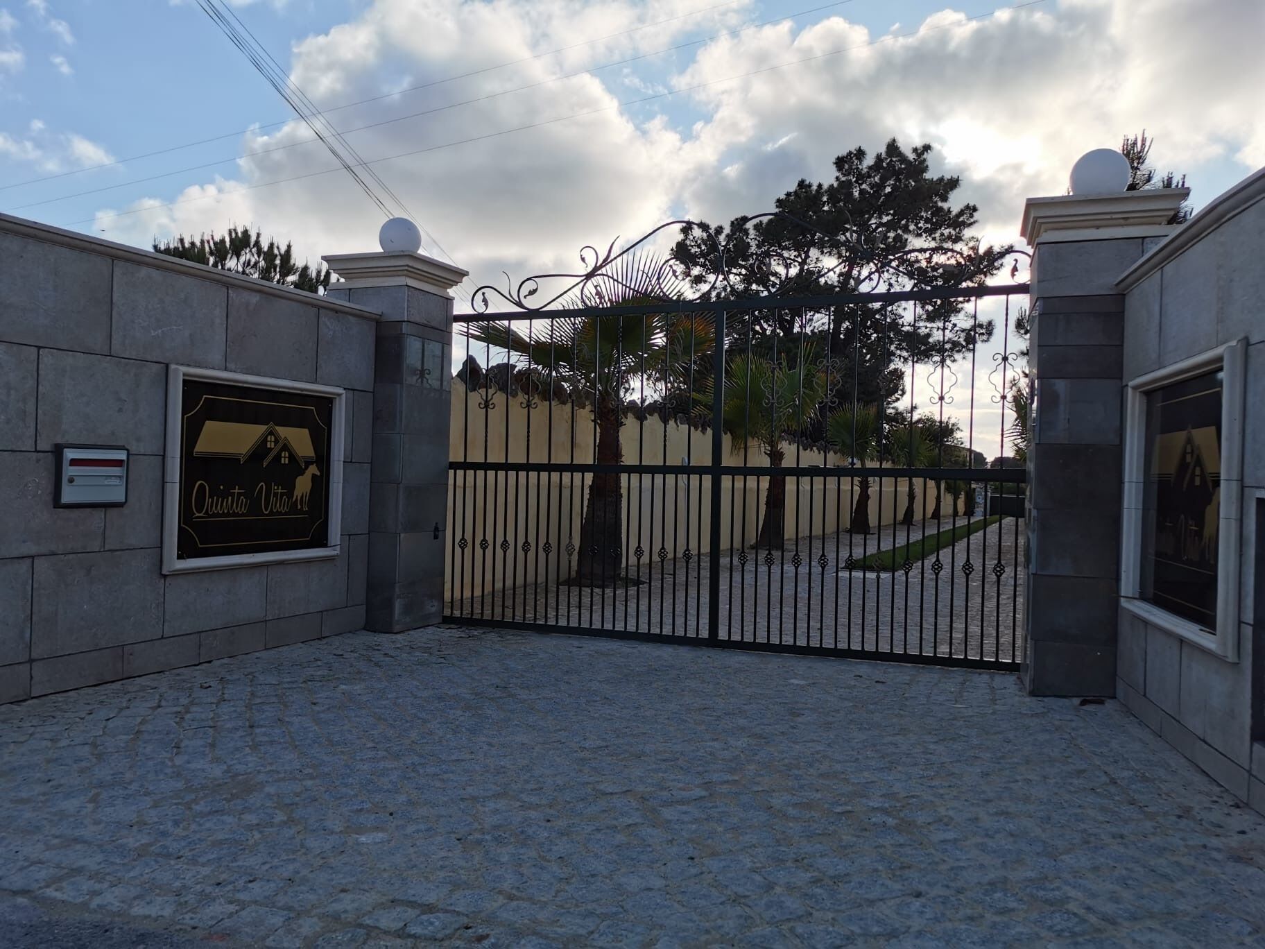 Uma entrada com portão e placa com a inscrição 'Quinta Vitoria'.