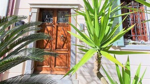 A building with a wooden door, green shutters, and a balcony with metal railings. - Franco House in the Old Town (Marina di Campo)