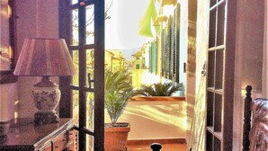 An open doorway leading to a street with buildings, a lamp, and a potted plant. - Franco House in the Old Town (Marina di Campo)