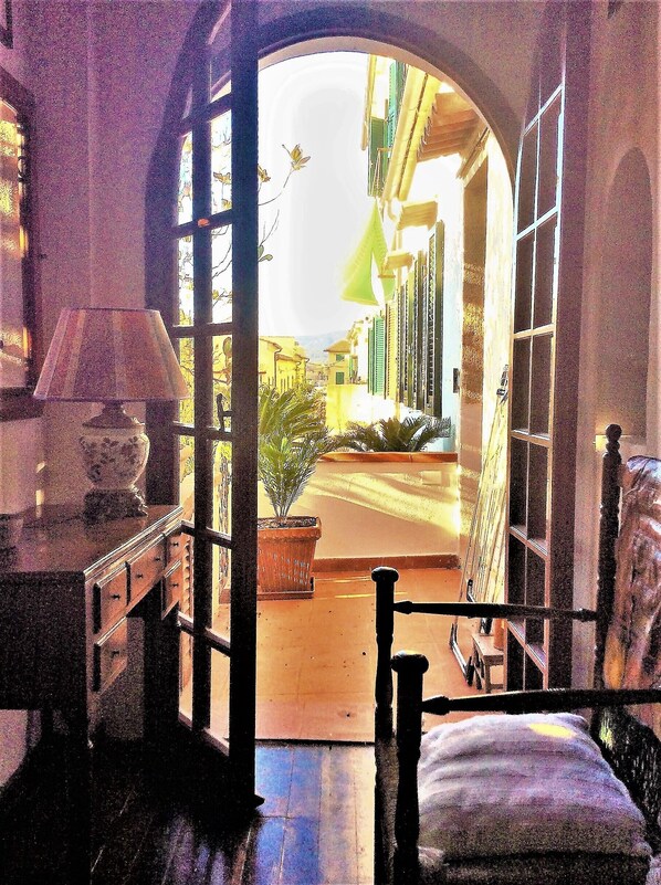 An open doorway leading to a street with buildings, a lamp, and a potted plant. - Franco House in the Old Town (Marina di Campo)