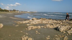 Une plage au paysage rocheux, avec des vagues.