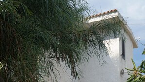A white building with a tiled roof, a door, and a small window. - beautiful apartment in villa, private beach with umbrellas and sunbeds (Marzamemi)