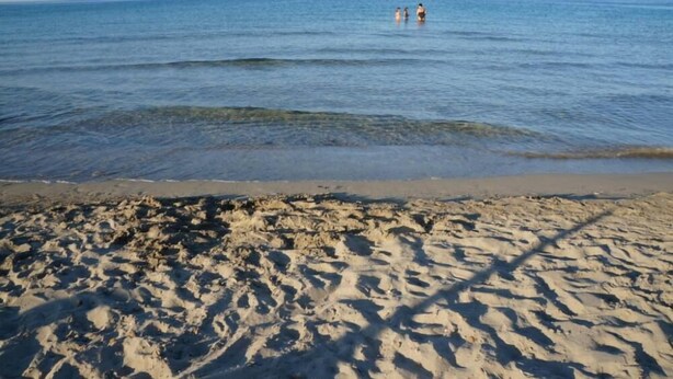 A sandy beach with three people in the water. - beautiful apartment in villa, private beach with umbrellas and sunbeds (Marzamemi)