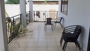 A balcony with tiled flooring, two chairs, and a railing. - 6 BEDROOM HOUSE  IN COMMUNITY 20, GREATER ACCRA , TEMA OFF THE SPINTEX ROAD (Tema New Town)