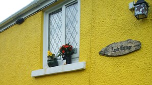 A yellow building with a sign reading "Apple Cottage." - Traditional Stone Cottage (Ammanford)