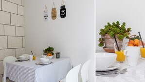 Un comedor con una mesa preparada para el desayuno, incluyendo cuencos, platos y una planta en maceta.