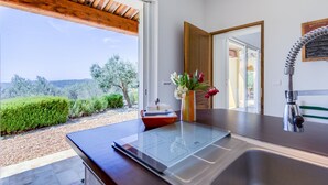 A modern kitchen with a large window, a stainless steel sink, and a wooden ceiling. - Large Villa with heated pool and stunning views set among olive trees (Callas)