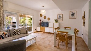 Una sala de estar moderna con sofá, mesa de centro y comedor con sillas y una mesa.