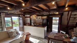 A cozy cabin interior with a living area, kitchenette, and a dining space.