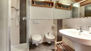 Ein modernes Badezimmer mit Dusche, Toilette, Bidet und einem großen Waschbecken.