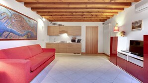 Eine moderne Küche mit Holzausstattung, einem roten Sofa und einem großen Stadtbild an der Wand.