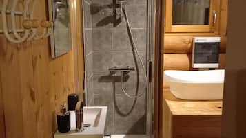 Une salle de bain moderne avec une douche à parois de verre, un lavabo blanc et un meuble-lavabo en bois.