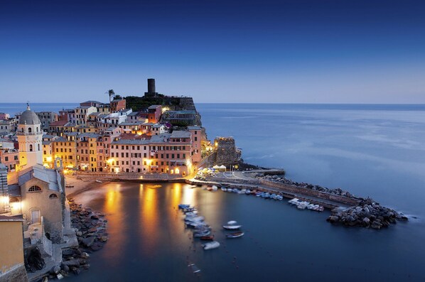 A coastal town with historic buildings, a prominent church, and a fortified structure overlooking the sea.