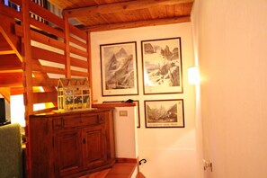 A room with wooden beams, a cabinet, and framed pictures on the wall. - Apartment Pré Saint Didier for rent / 6 - 8 people (PRE' SAINT DIDIER)