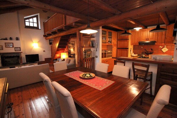 A cozy dining area with a wooden table, chairs, and a red placemat. - Apartment Pré Saint Didier for rent / 6 - 8 people (PRE' SAINT DIDIER)