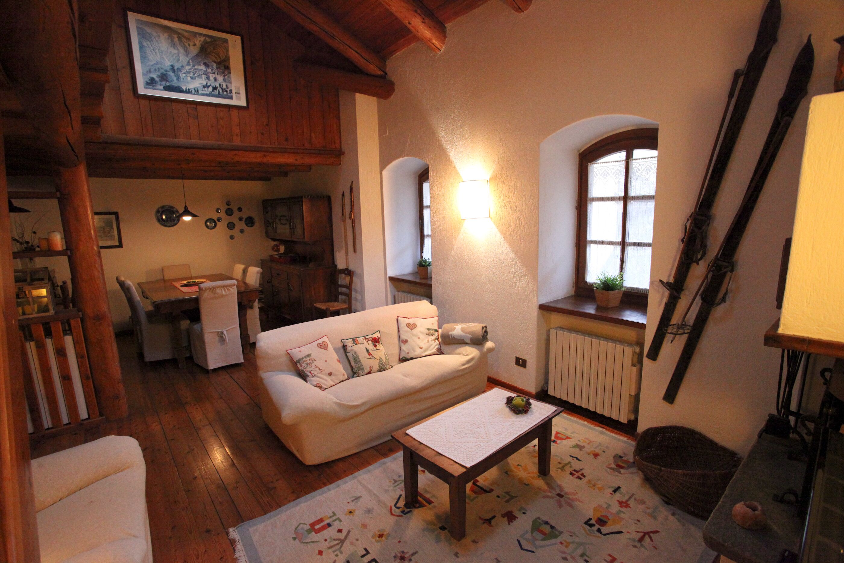 Una sala de estar acogedora con un sofá, una mesa de centro y un comedor con una mesa y sillas.