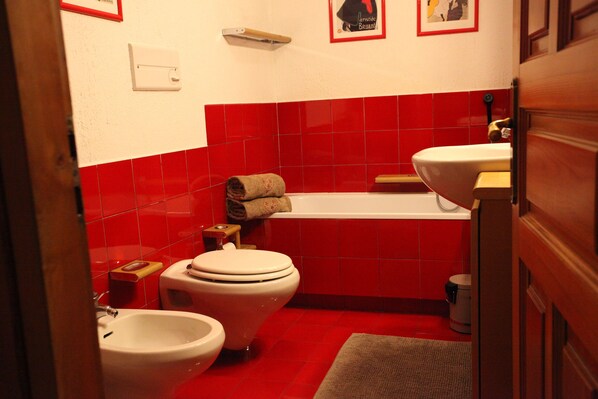 A bathroom with a toilet, bidet, and bathtub.