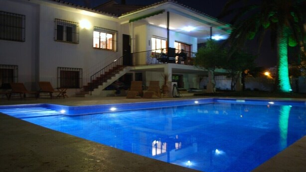 Ein Schwimmbecken mit einem zweistöckigen Haus im Hintergrund.