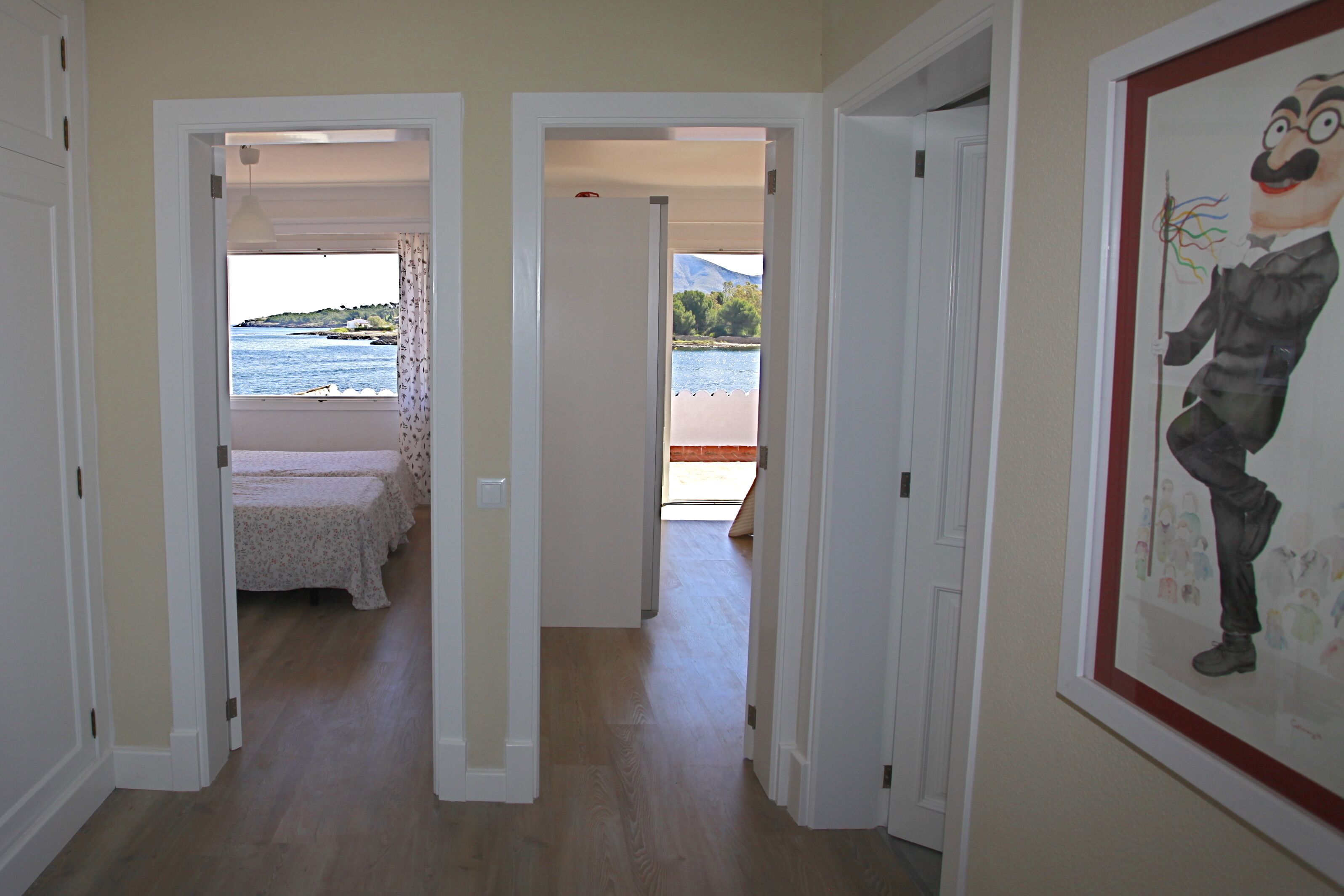 A hallway with a bed and a view of a lake.