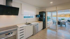 A modern kitchen with a built-in oven, a dishwasher, and a window overlooking a scenic view. - TRANQUILITY, REST AND RELAXATION BY THE SEA.  IN WINTER CENTRAL HEATING  (Alcudia)