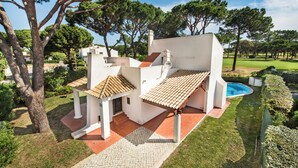A villa with a swimming pool, a paved driveway, and a well-maintained garden. - Perfect Retreat Overlooking Pinhal Golf Course, Private pool, Off-street parking (Vilamoura)