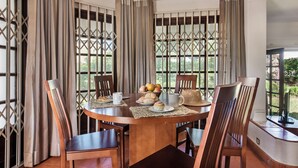 A dining area with a round table, chairs, a bowl of fruit, and a coffee mug. - Perfect Retreat Overlooking Pinhal Golf Course, Private pool, Off-street parking (Vilamoura)