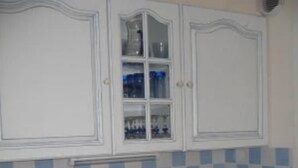 A kitchen with white cabinets, a checkered backsplash, and a sink. - Cosy 3*** flat (Ouistreham)