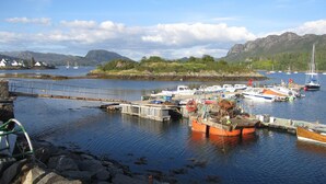 A harbor with boats docked, a bridge, and rocky shores. - Fabulous House with Stunning Sea Views to Skye. By NTS gardens. Great Privacy. (Kyle of Lochalsh)