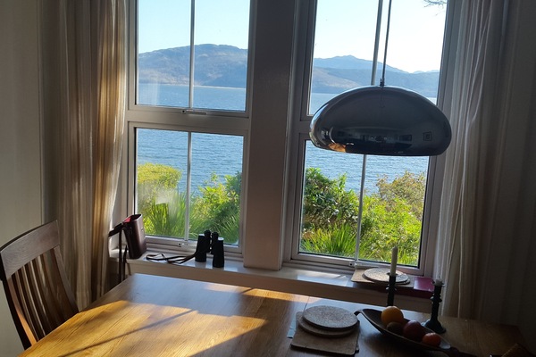 The oak dining-table looks out directly over the sea.