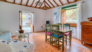 Une pièce chaleureuse avec un plafond en bois, une table à manger avec des chaises, un canapé et une commode.