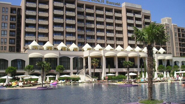 Ein Hotel mit großem Poolbereich, mehreren Balkonen und Außenbereich zum Sitzen.