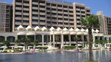 Ein Hotel mit großzügiger Poolanlage, mehreren Balkonen und einem Schild mit der Aufschrift 'ROYAL BEACH Barceló'.