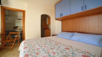 Una camera da letto con un letto, una testiera in legno e un armadio.