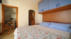 Una camera da letto con un letto, una testiera in legno e un armadio.