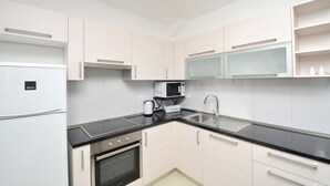 A modern kitchen with white cabinets, a black countertop, a built-in microwave, a stove, and a sink. - Apartment Palm Beach 2 for 6-8 persons - Amazing beach house rental! (Okrug Gornji)