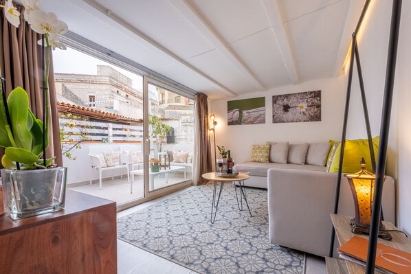 Ein modernes Wohnzimmer mit einer Couch, einem Couchtisch und einer Zimmerpflanze.