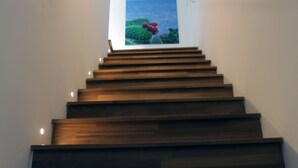 A wooden staircase leading to a room with a view of the sea.