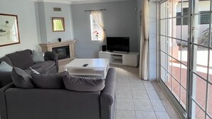Una sala de estar moderna con un sofá gris, un televisor de pantalla plana y una chimenea.