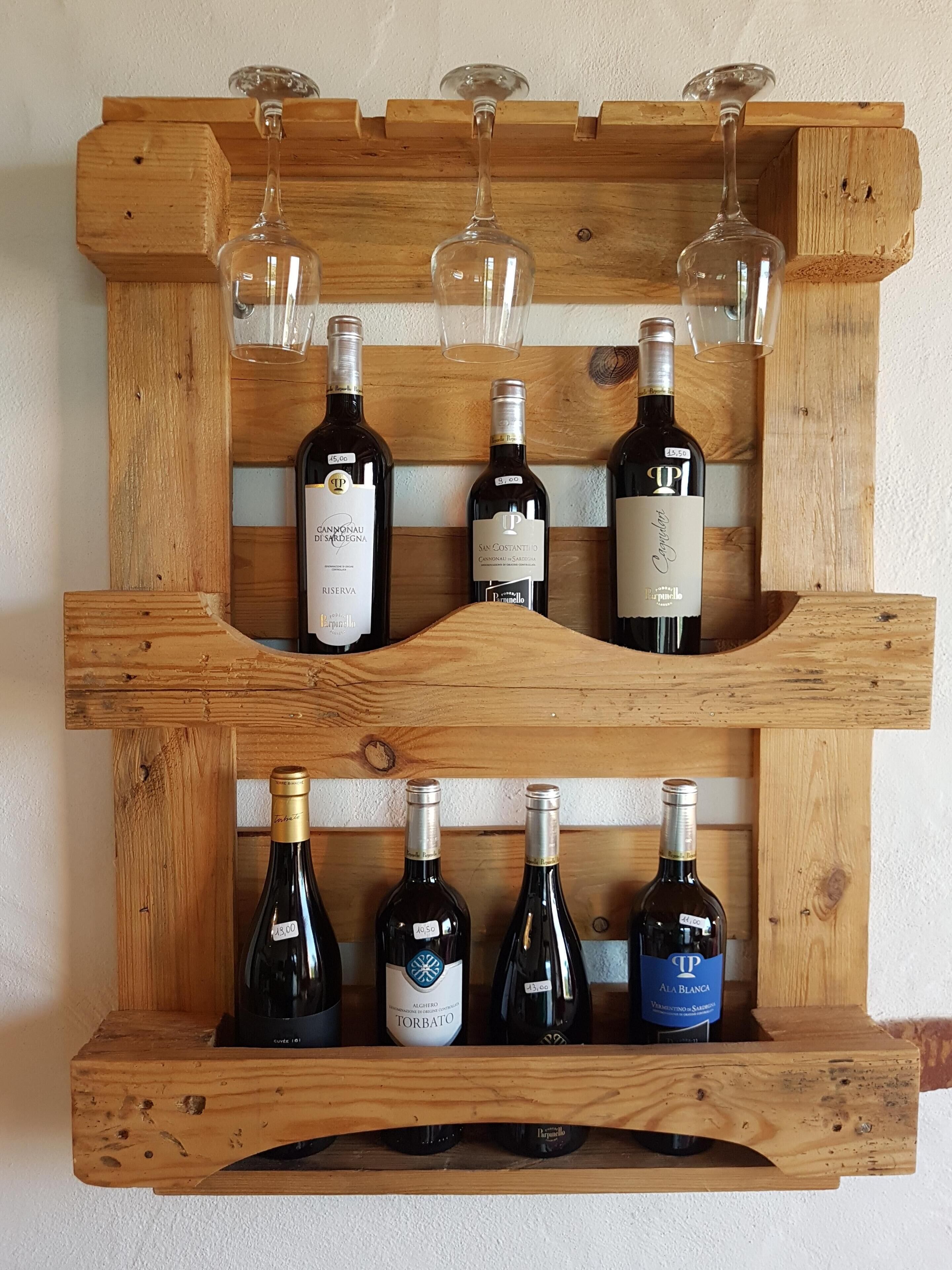 Una botellera de madera con seis botellas y seis copas.