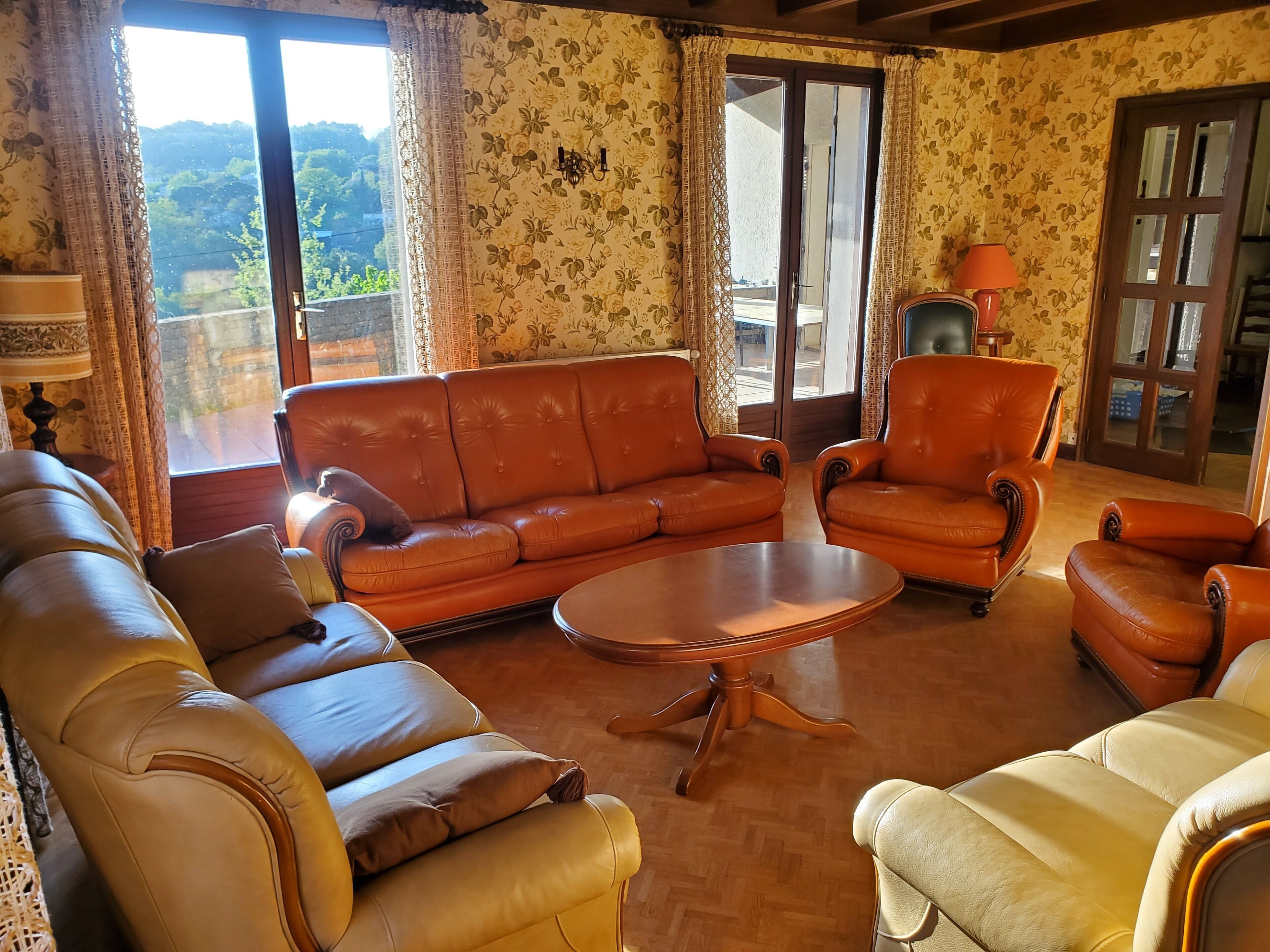 A living room with a brown leather sofa, a yellow armchair, and a wooden coffee table.
