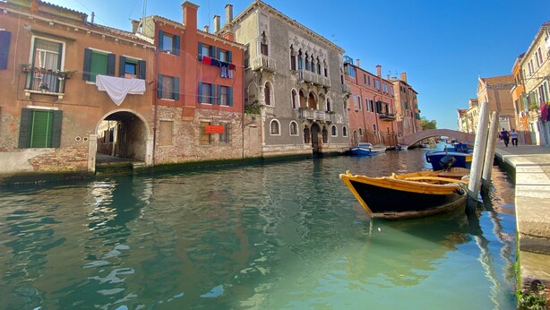 Un canal flanqueado por edificios, un puente y barcos.