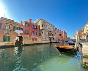 A canal with buildings on either side, a bridge, and boats. - CA CAMMELLO - Private Terrace and Canal View (Venezia)
