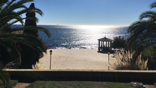 A beach view with a gazebo and palm trees. - Sun, Sea & Culture. Luxury Villa & Pool. Breathtaking Views to Sea. Inc WiFi (Santa Cristina d'Aro)