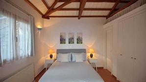 A bedroom with a large bed, two bedside tables with lamps, a radiator, and a wardrobe. - Alonissos/Alonnisos - Idyllic Villa with private beach & jacuzzi,  amazing views (Alonissos)