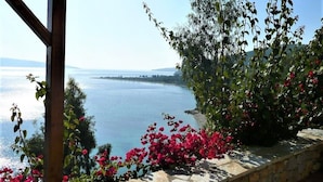 A stone wall with a view of a calm sea and distant land. - Alonissos/Alonnisos - Idyllic Villa with private beach & jacuzzi,  amazing views (Alonissos)