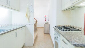 A kitchen with white cabinets, a granite countertop, a stove, and a tiled backsplash. - Sea View !!! 2 bedrooms (Almancil)
