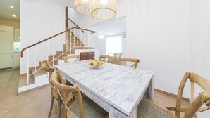 A dining area with a wooden table and chairs, a fruit bowl, and a staircase with a railing. - Sea View !!! 2 bedrooms (Almancil)