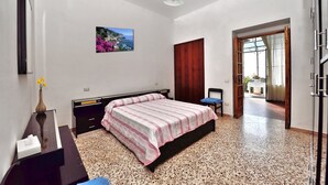 A bedroom with a bed, a desk, a chair, a picture on the wall, and a door leading to another room. - B&B NARCISO with private parking (Conca dei Marini, Campania)