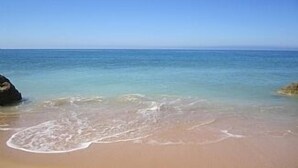 Una spiaggia con acque cristalline e una riva sabbiosa.