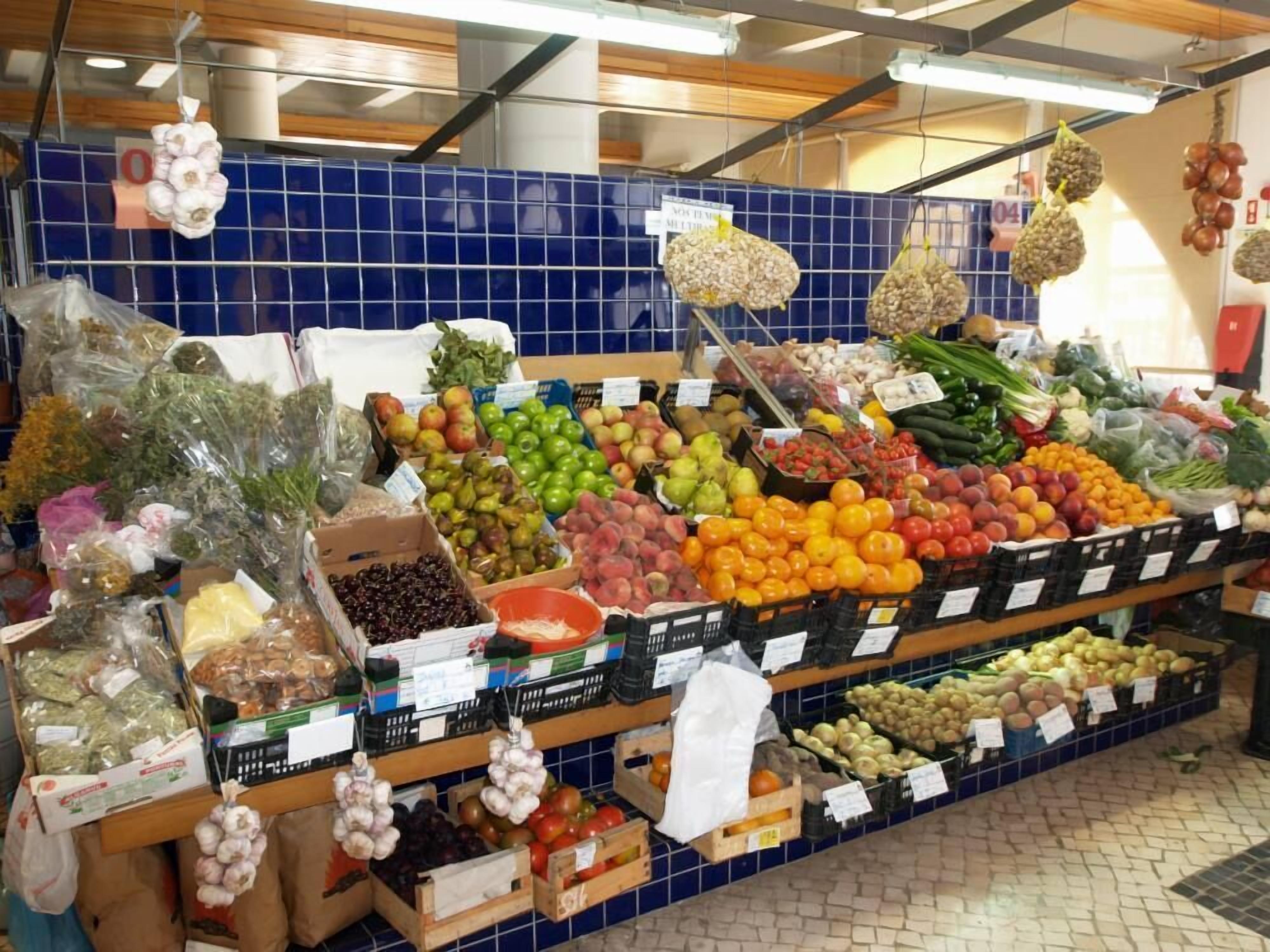 A grocery store with various fruits and vegetables on display.